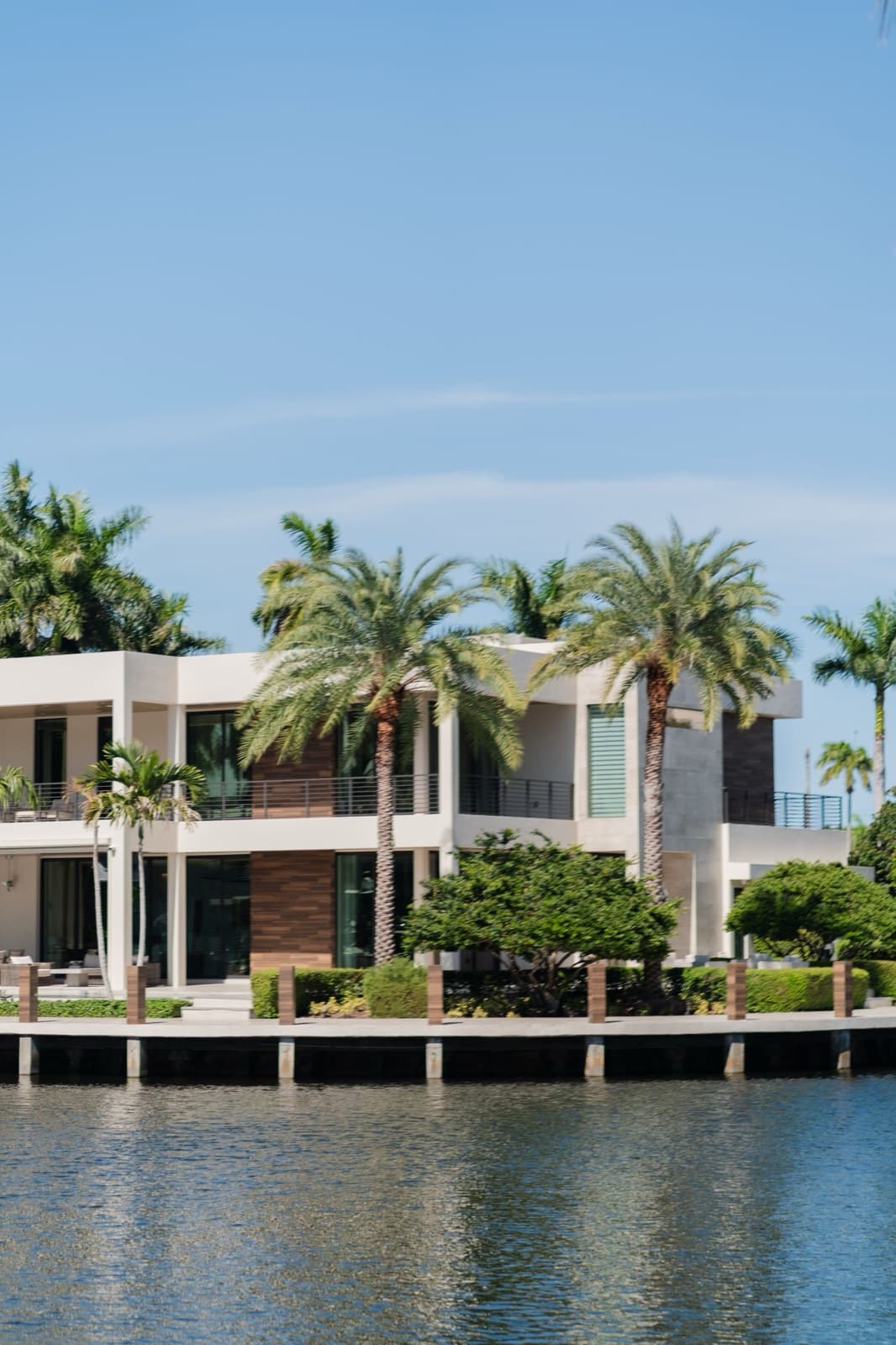 Modern waterfront villa with palm trees