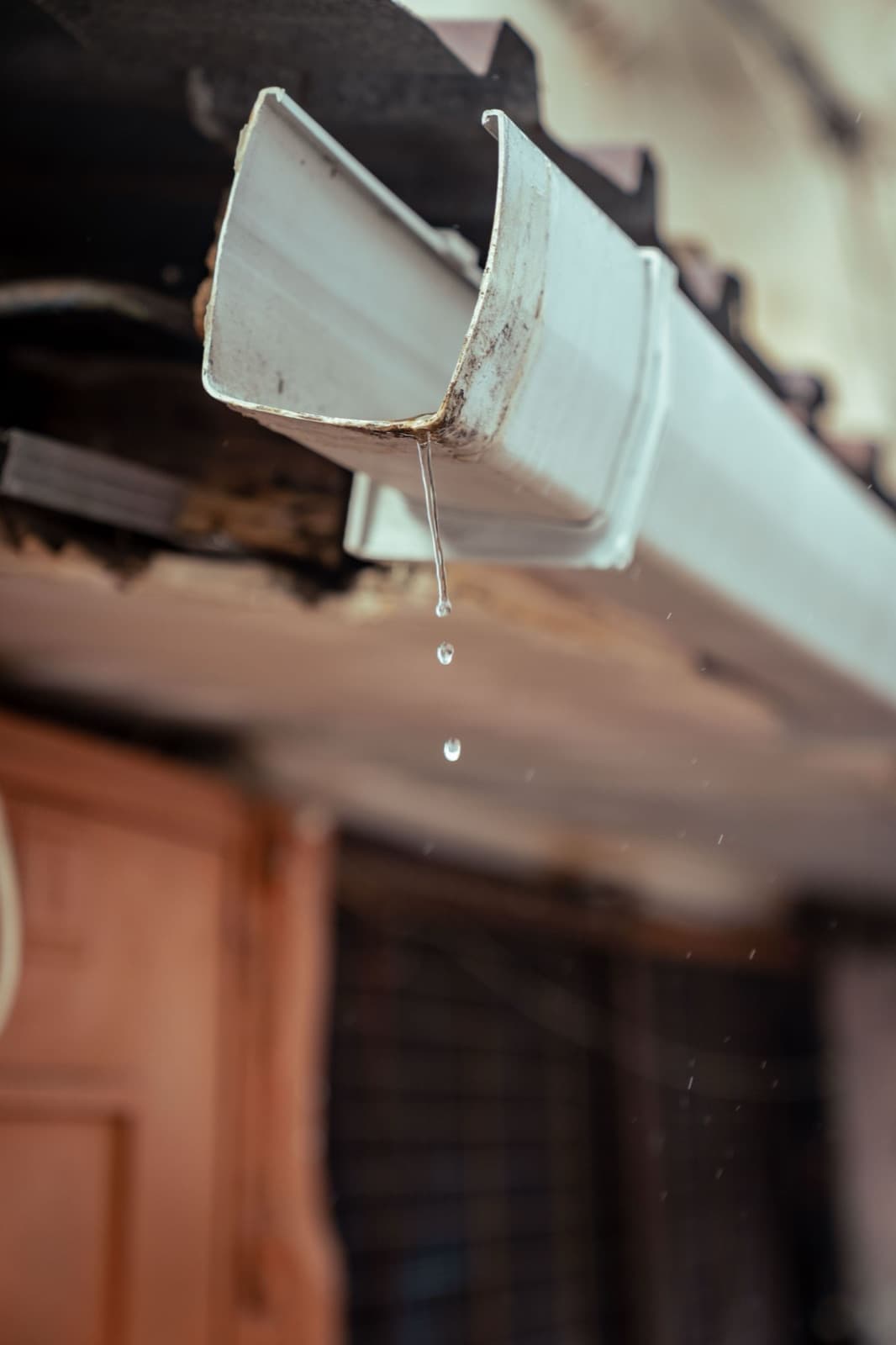 Rainwater flowing from a residential gutter during a storm