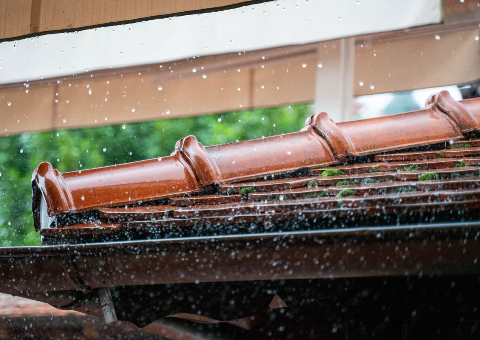 Rain running off a terracotta tile roof
