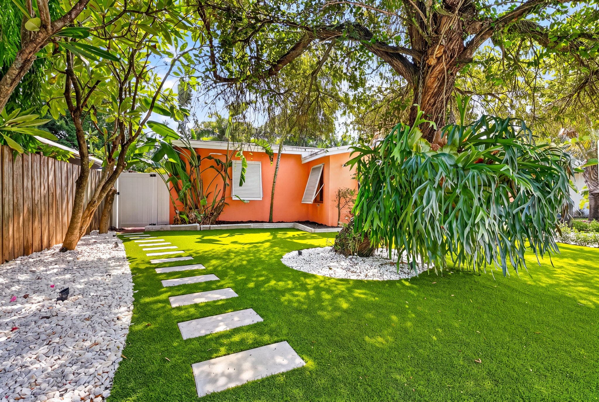 Stepping-stone pavers across new turf under the shade tree