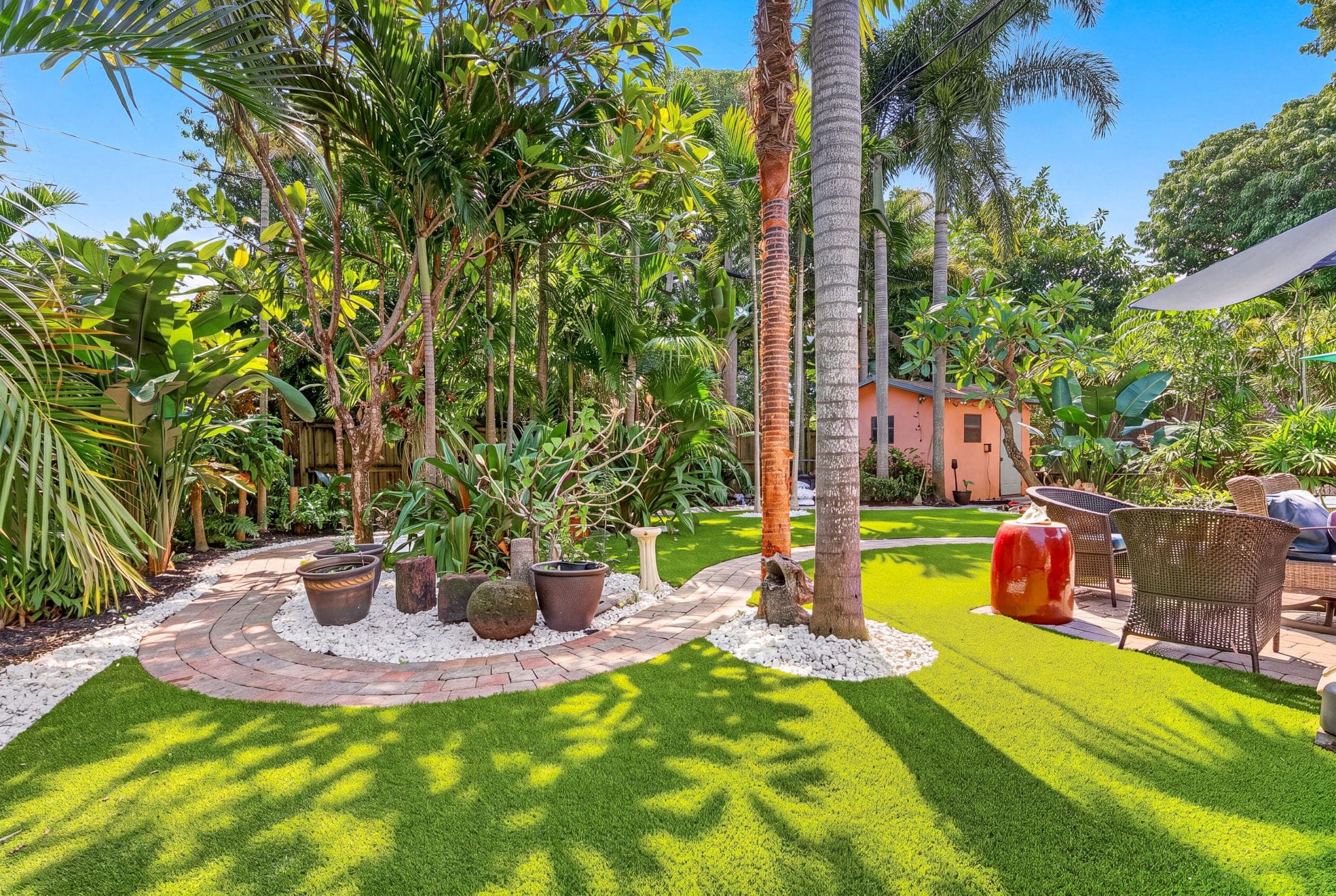 Wide view of the finished yard: turf, pavers and the palms kept in place