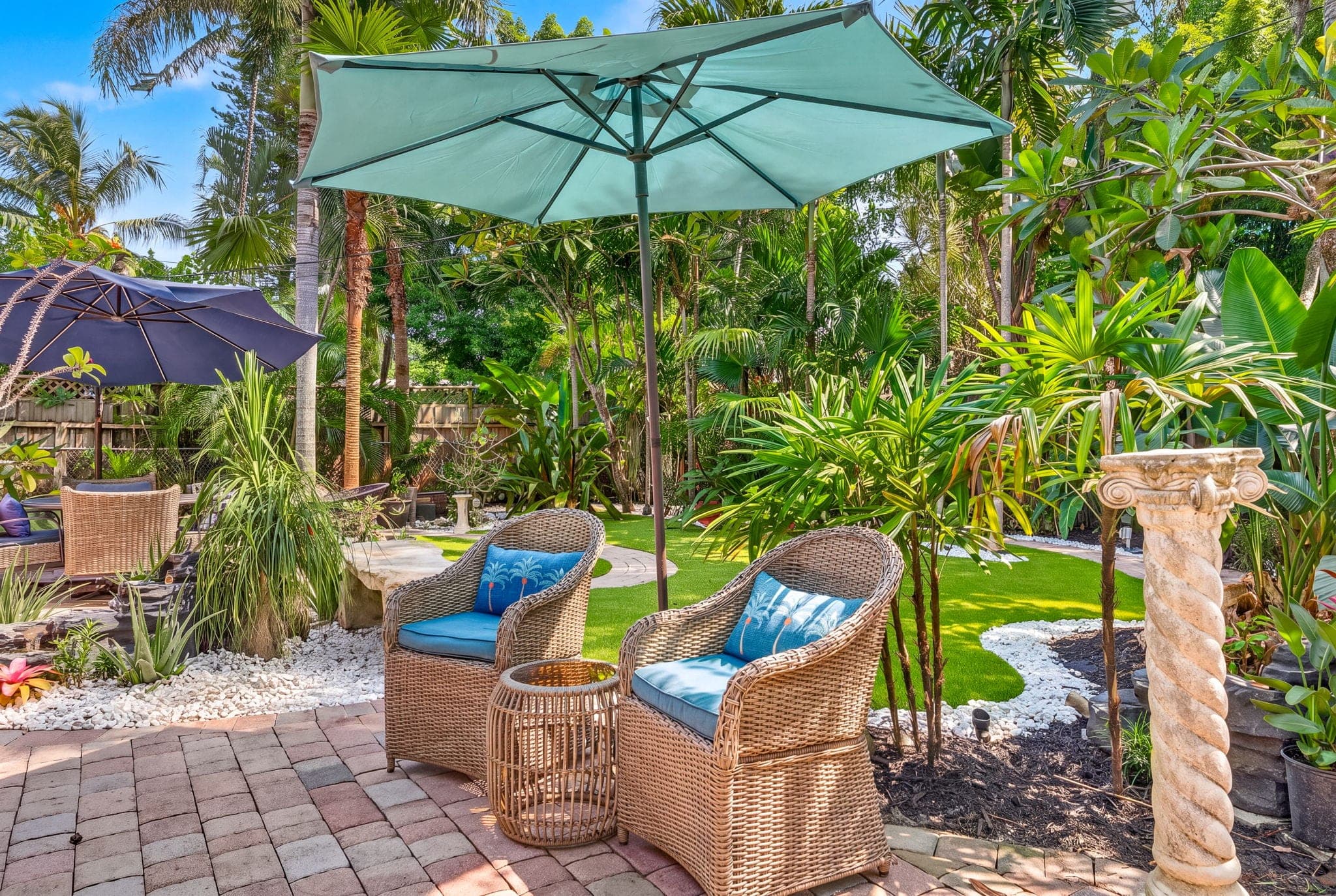 Wicker seating on pavers with the turf lawn beyond