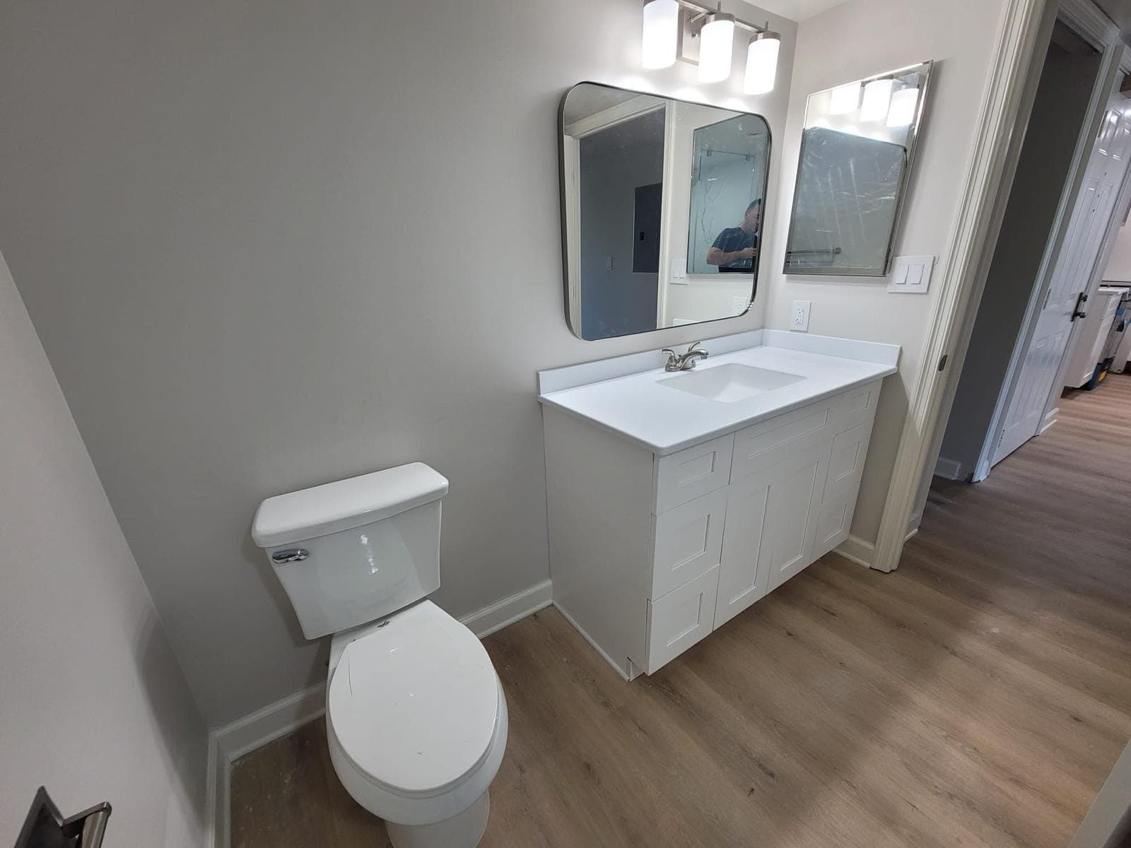 Bathroom with white vanity, framed mirror and marble-look shower