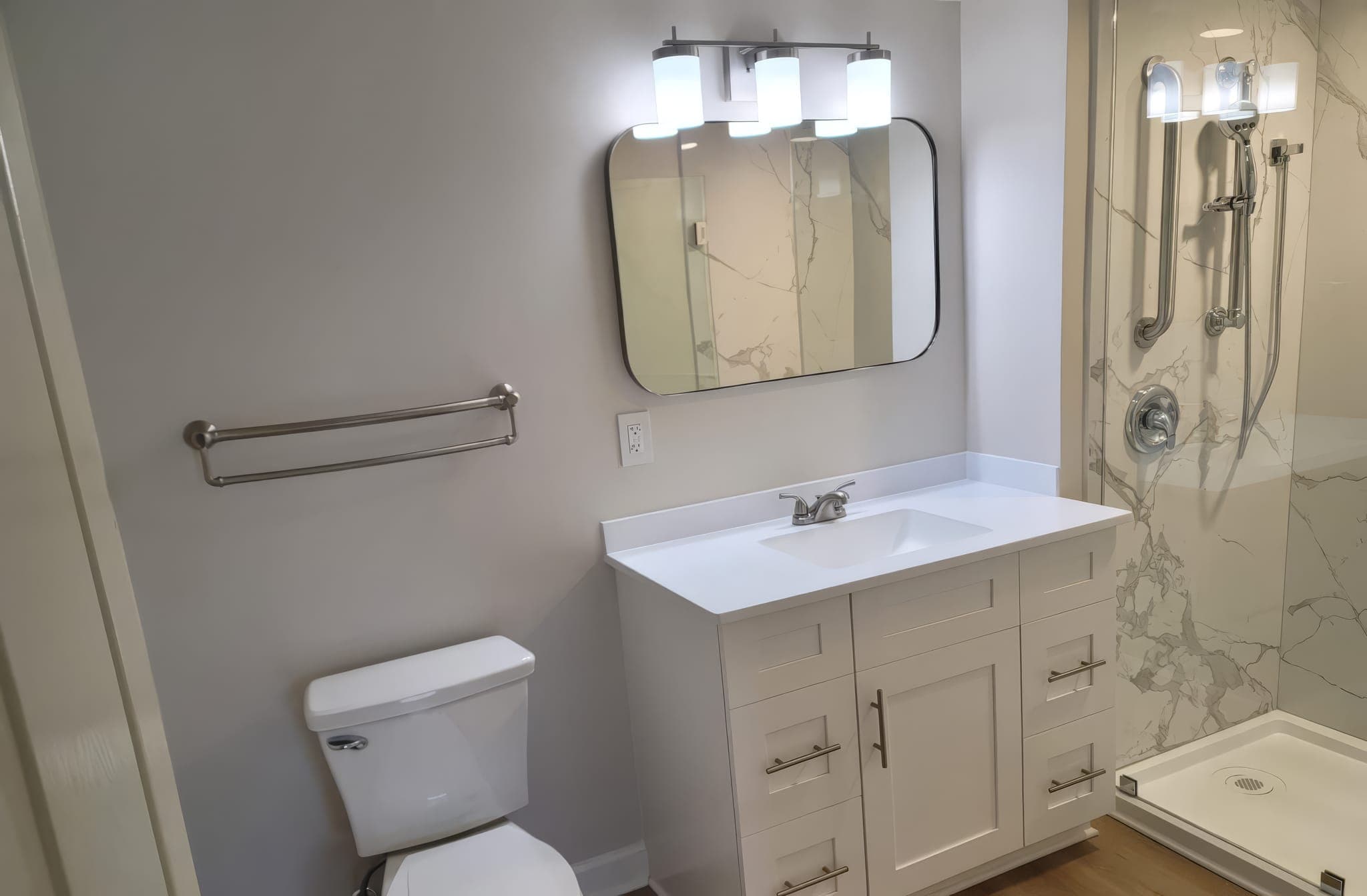 Vanity, toilet and shower in a remodeled bathroom