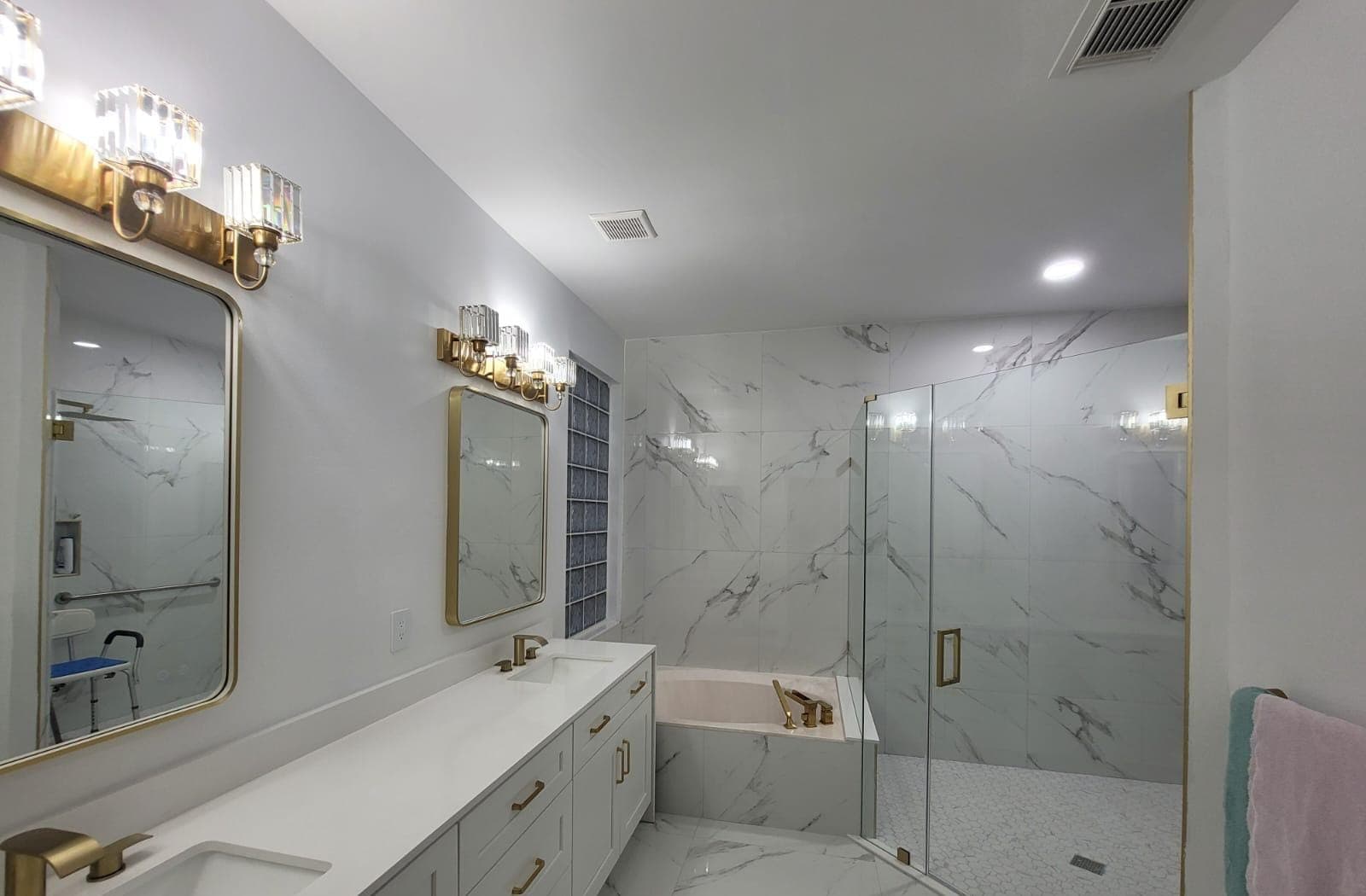 Bathroom remodeled by Sade Roofing with double vanity and frameless glass shower