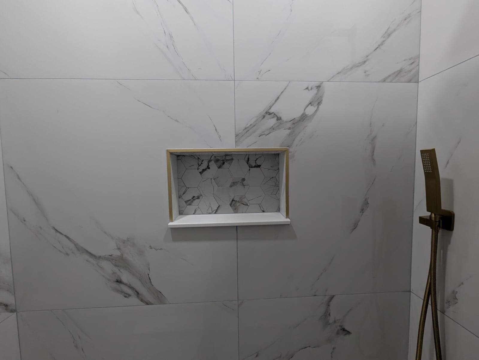 Shower niche trimmed in gold in marble-look porcelain