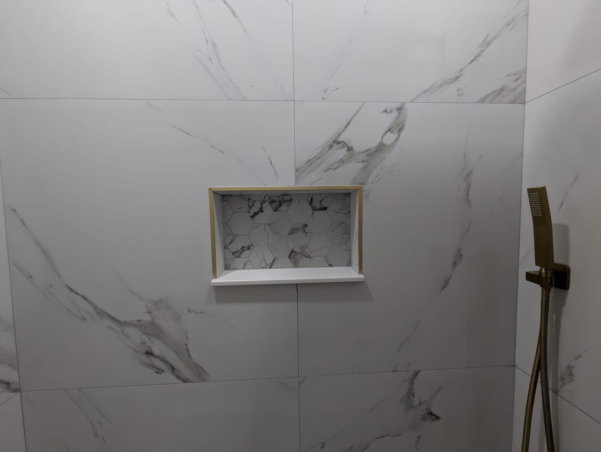Shower niche trimmed in gold in marble-look porcelain