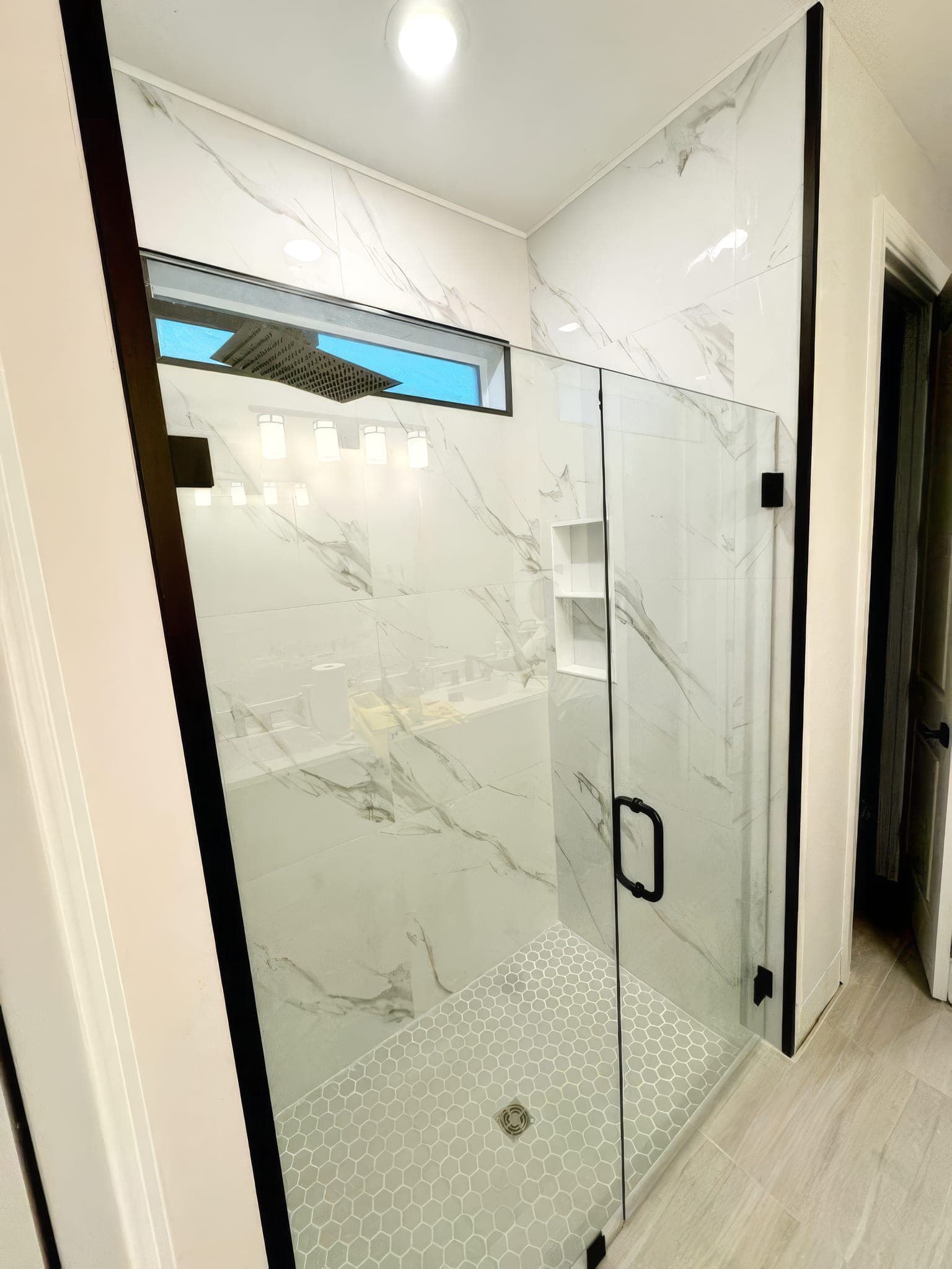 Walk-in shower with black hardware and recessed niche