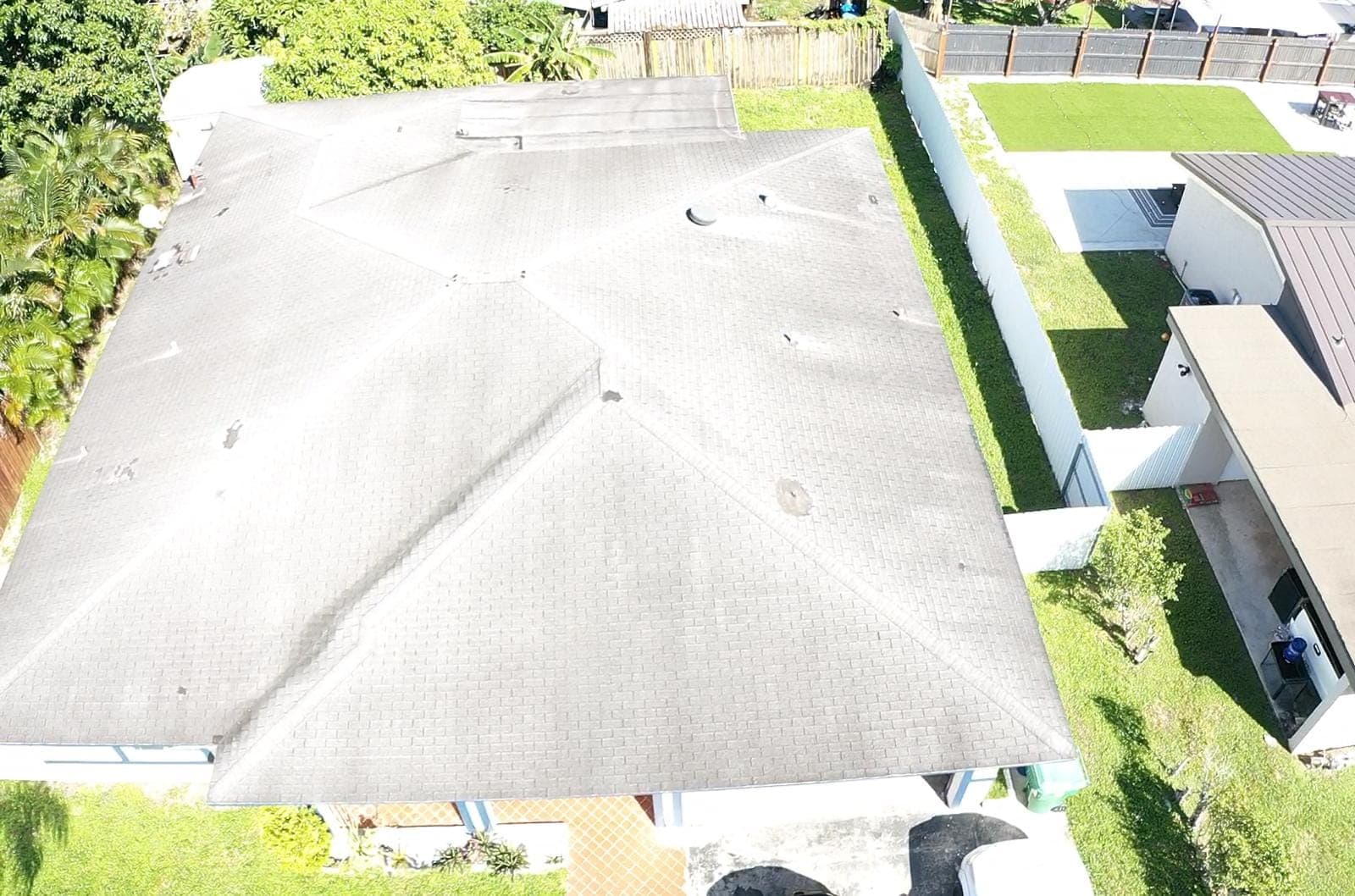 Drone view of a low-slope roof and surrounding yard