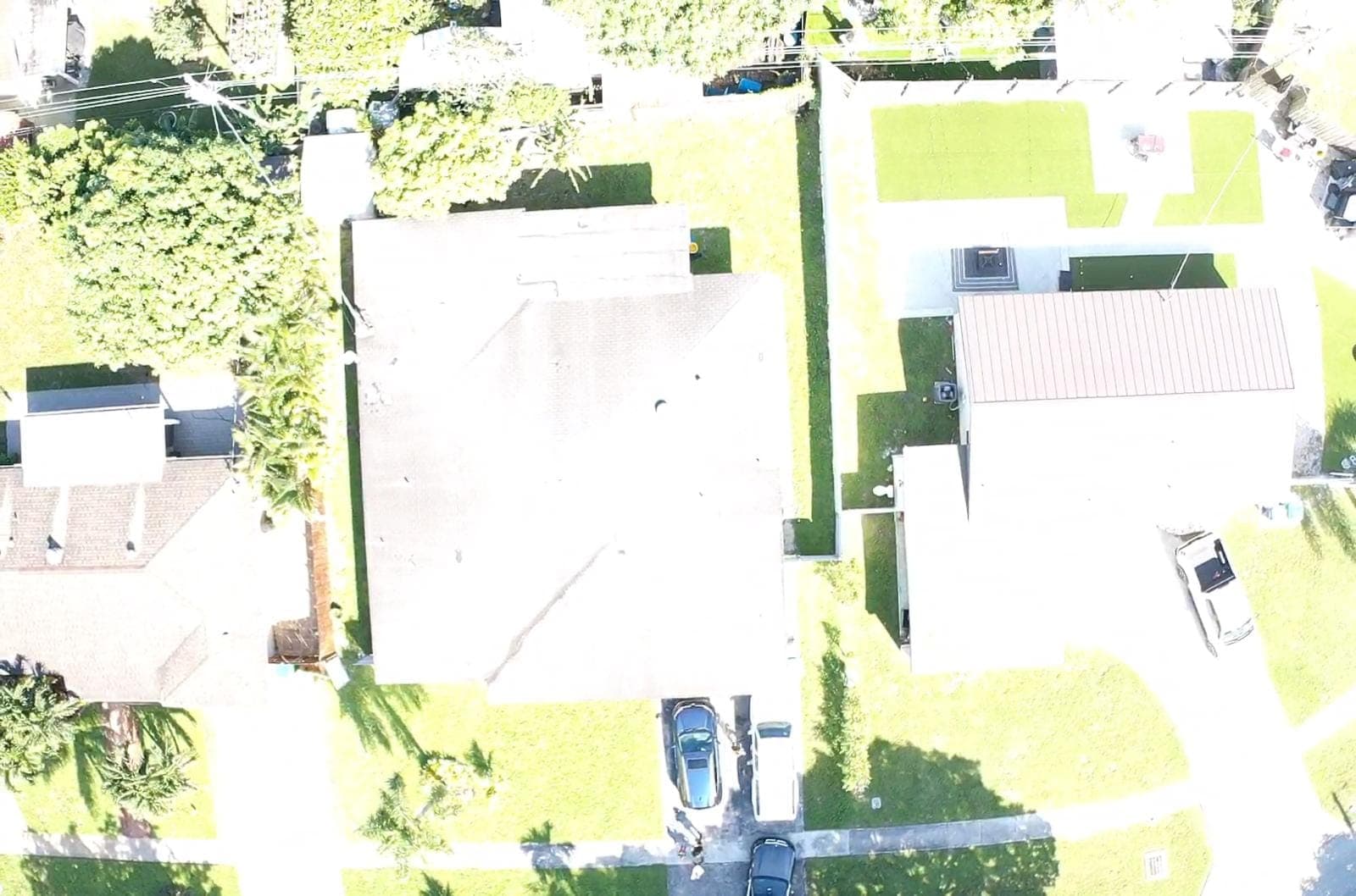 Aerial view of a flat-roofed home and neighbor's roof