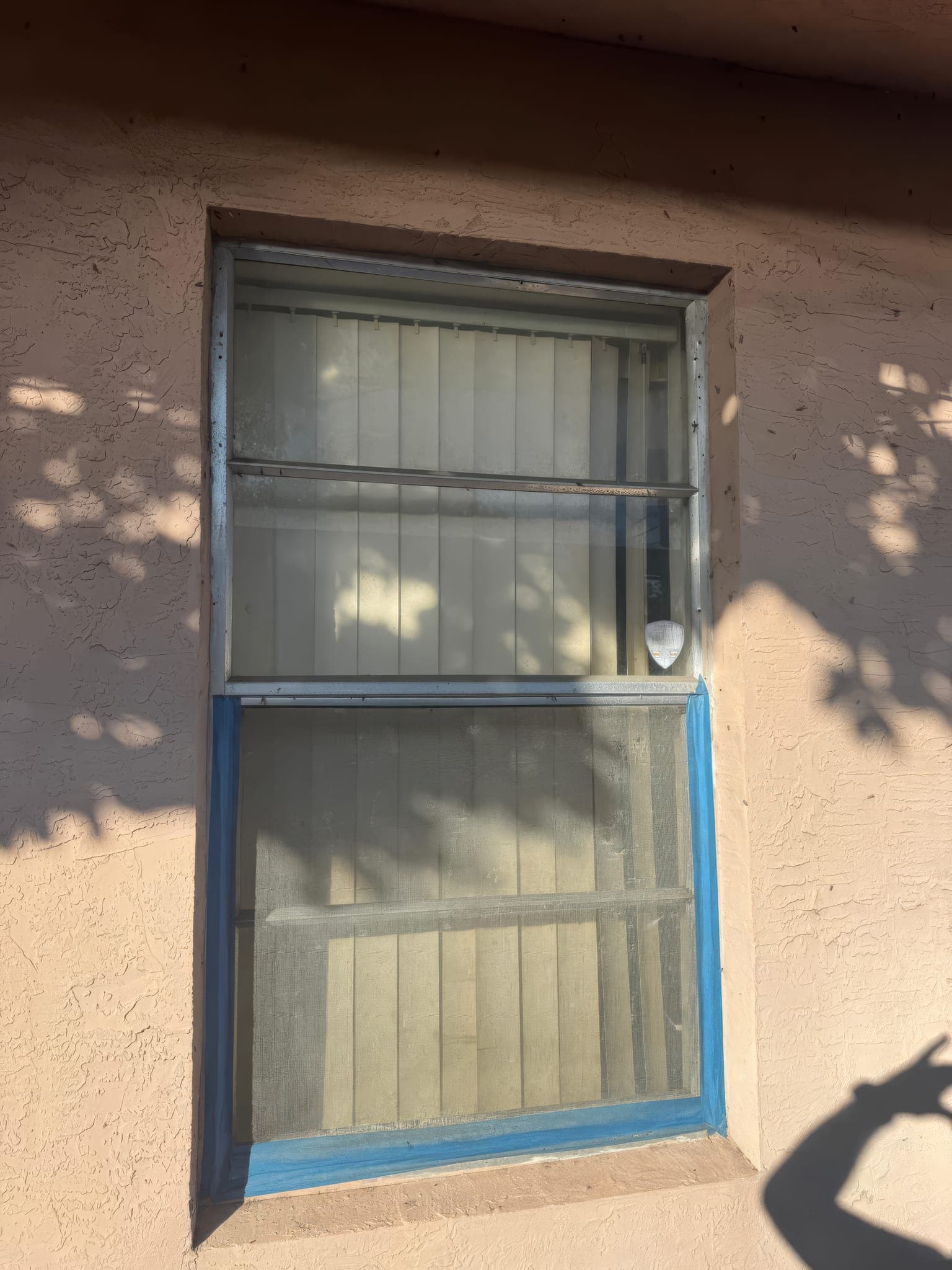 Original jalousie window marked for replacement