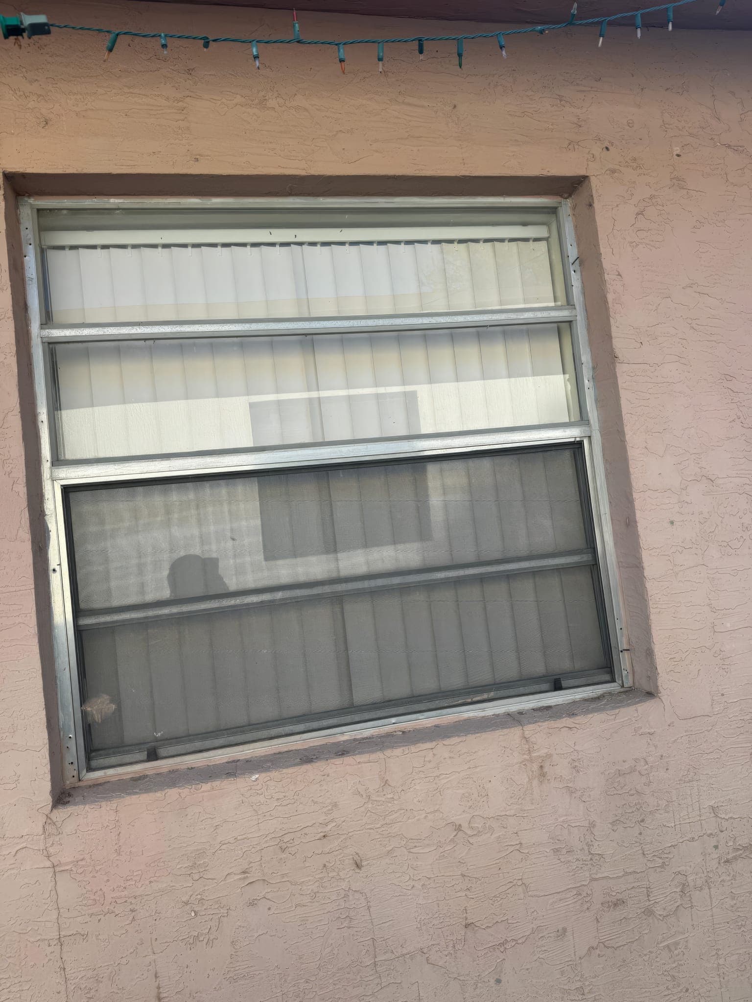 Large original jalousie window before replacement