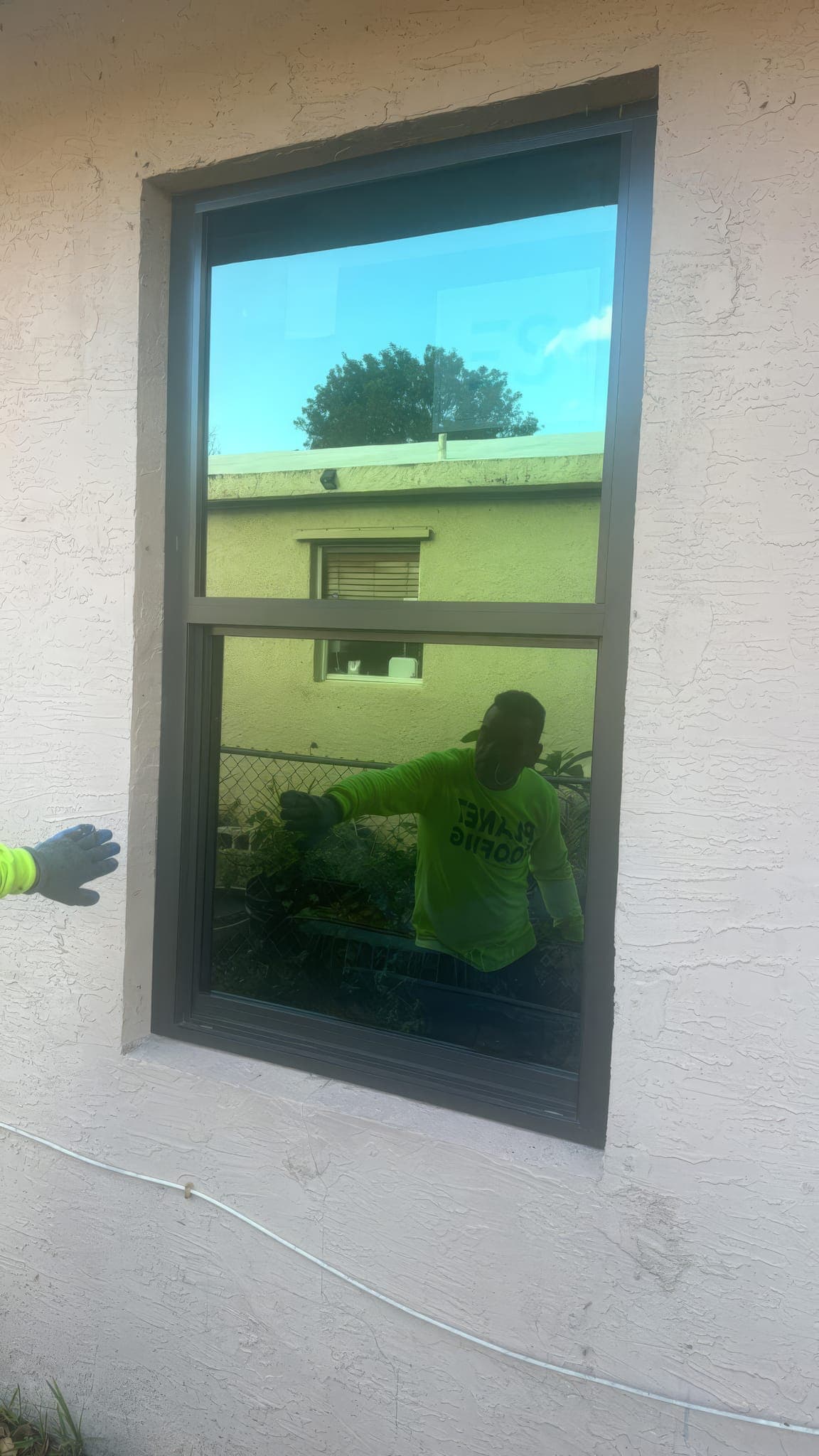 New impact-rated window with dark bronze frame installed in the side wall