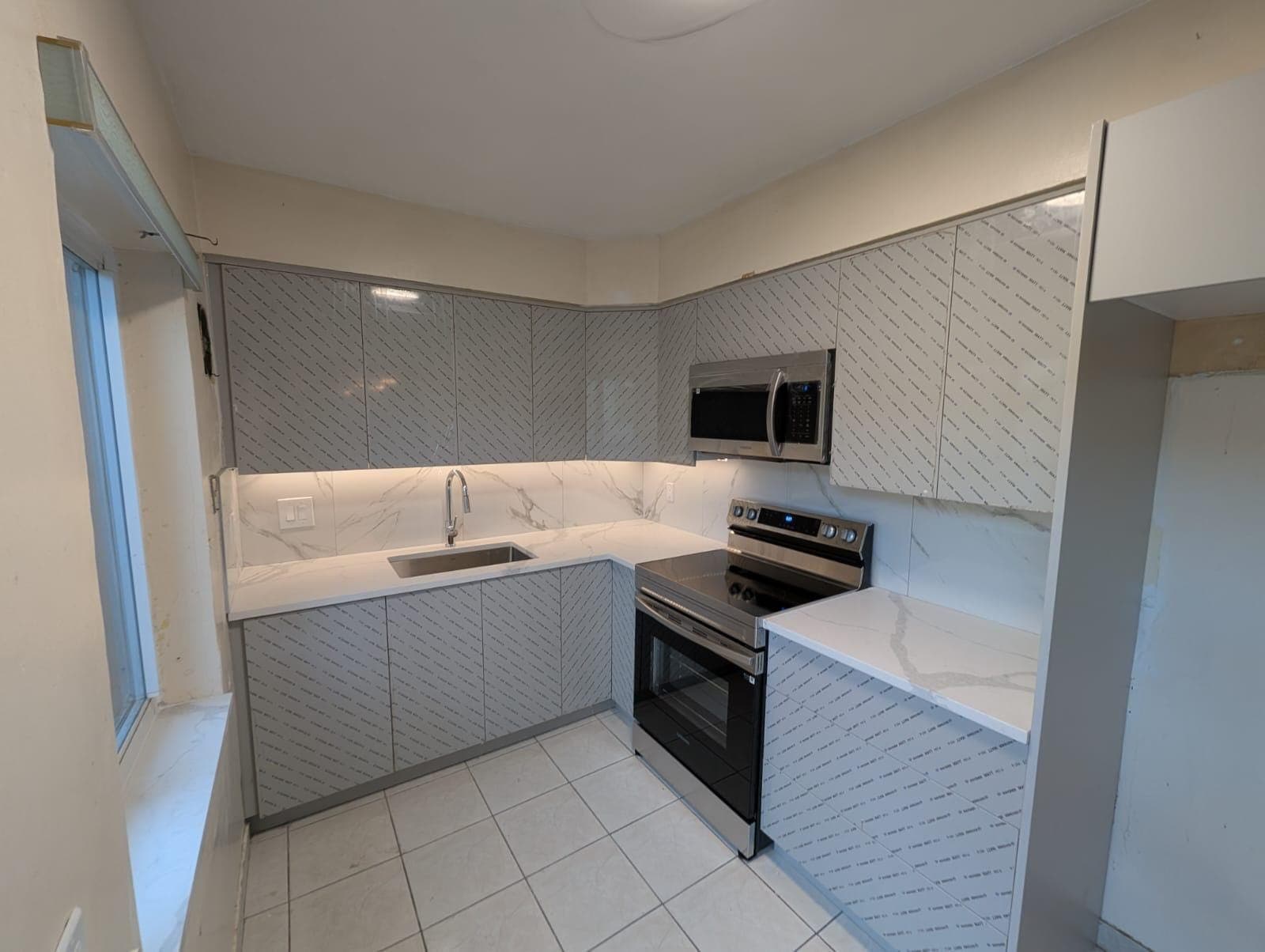 Finished run of grey cabinets with range and microwave