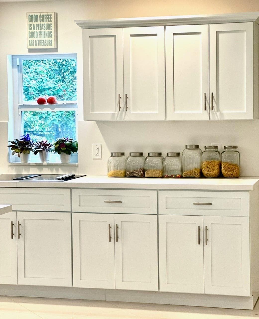 Kitchen window over the counter with white cabinetry and quartz top