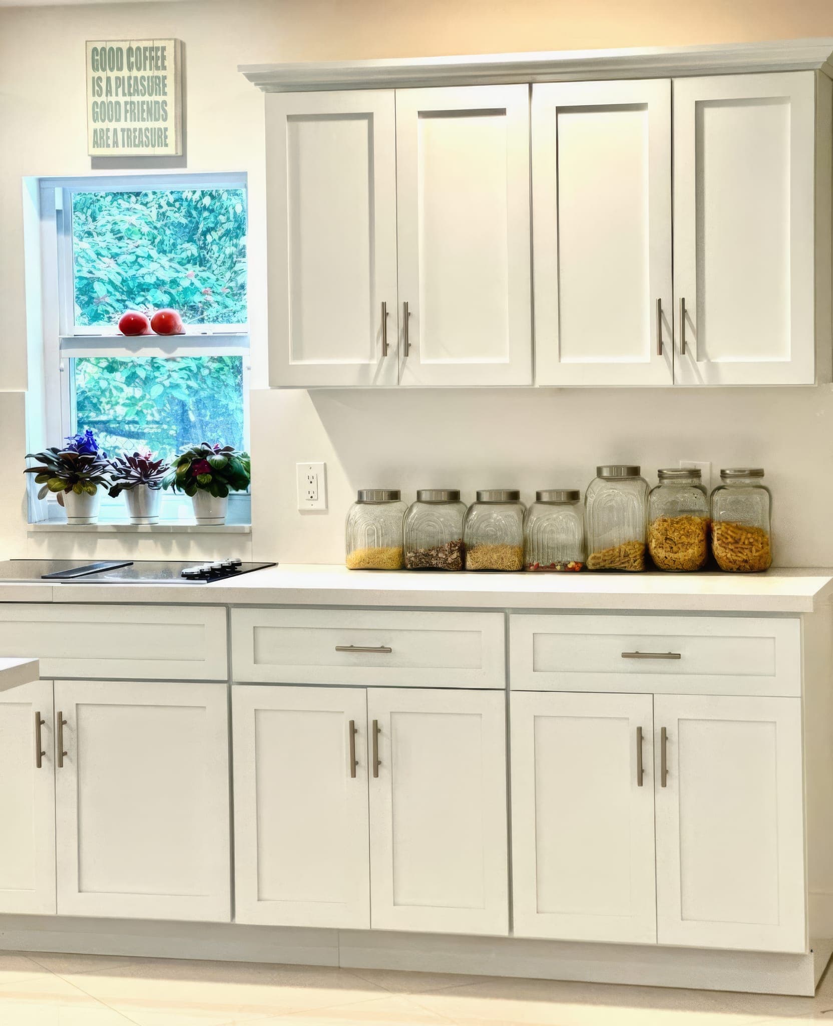 Kitchen window over the counter with white cabinetry and quartz top