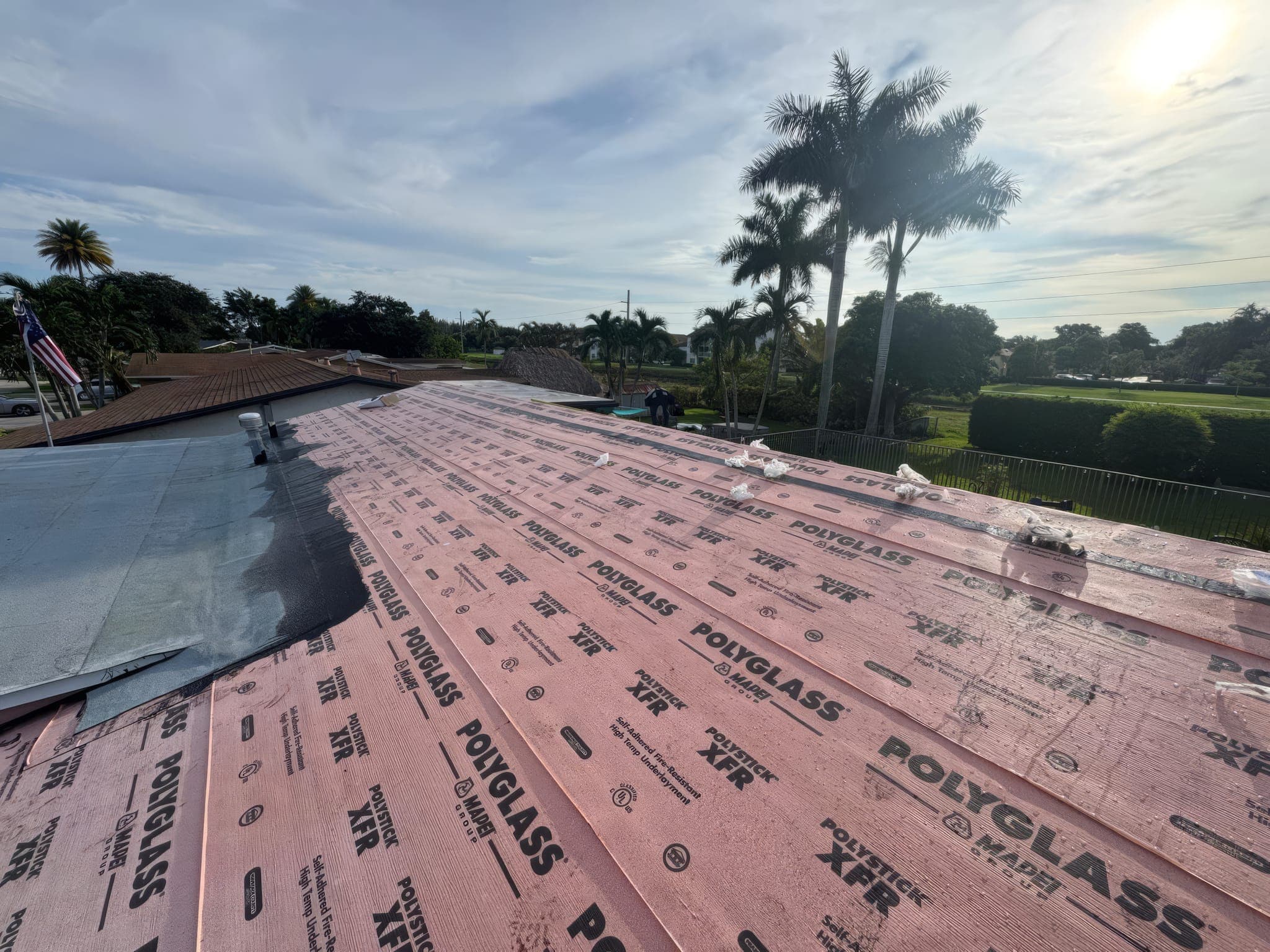 Dried-in roof deck with underlayment, seen from the ridge over the neighborhood