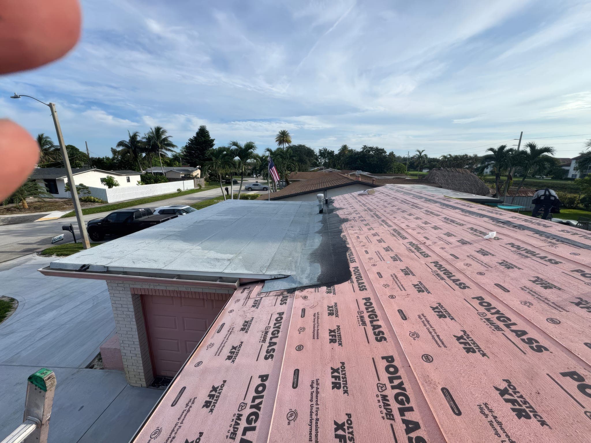 Underlayment across the main roof and the flat garage section before metal