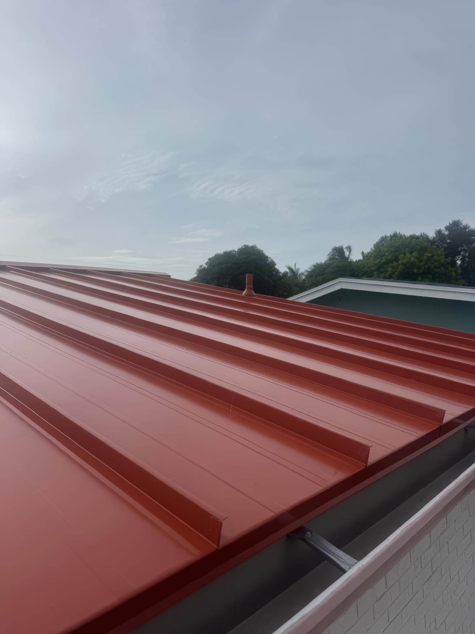 Finished red standing seam panels running down to the eave