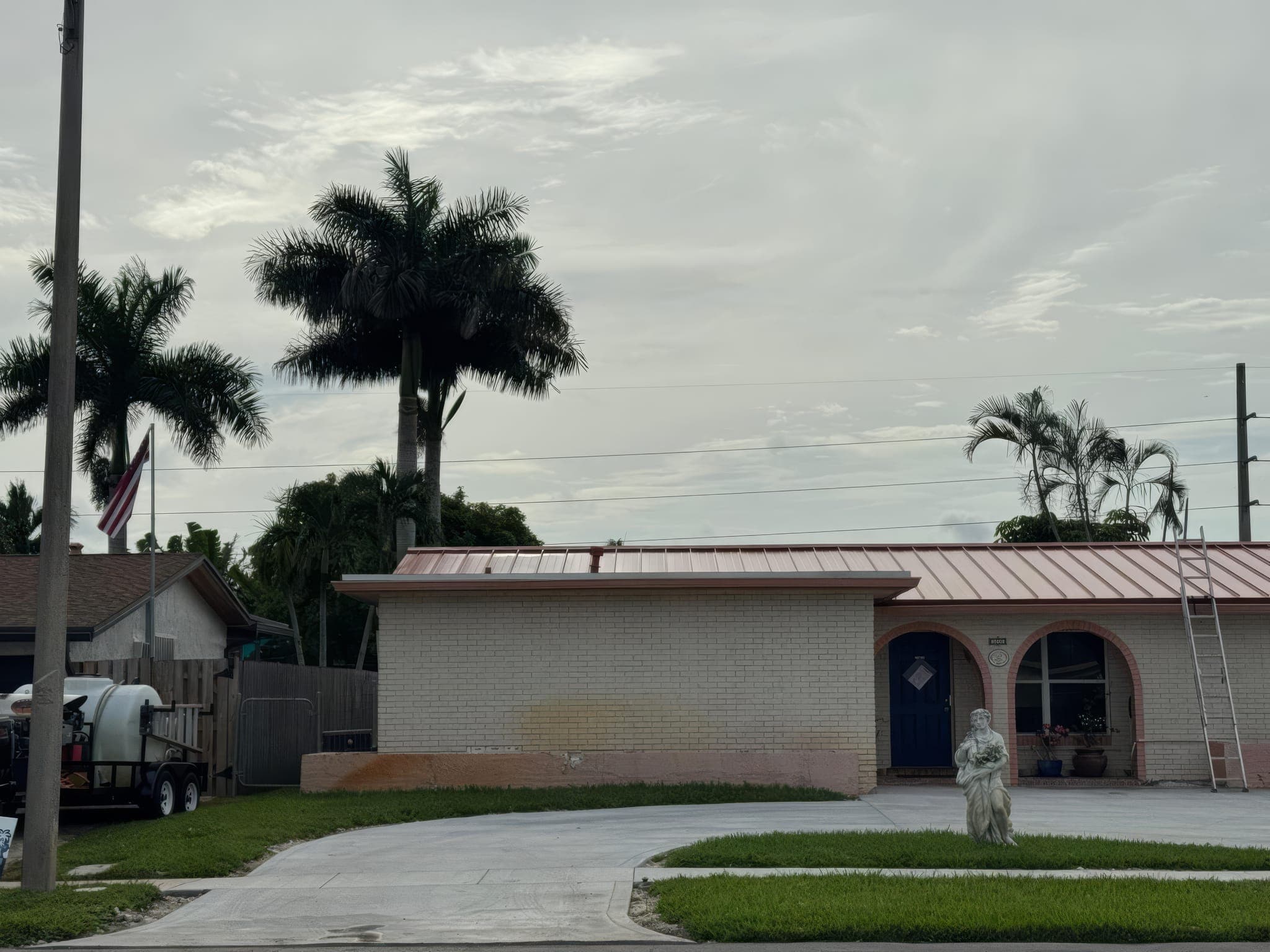 Street view of the finished red standing seam roof and arched entry