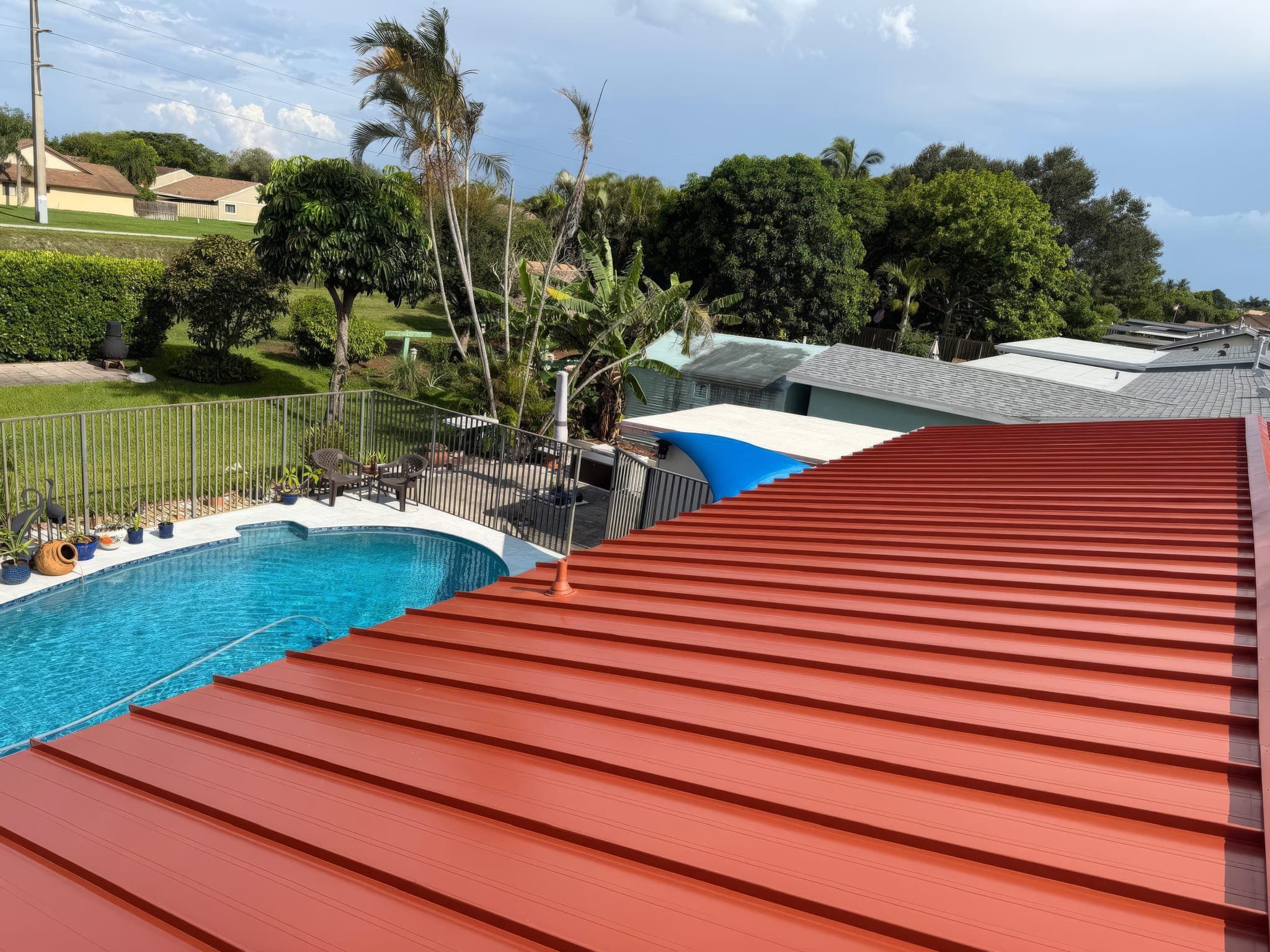 Drone view of the red metal roof over the pool and screen enclosure