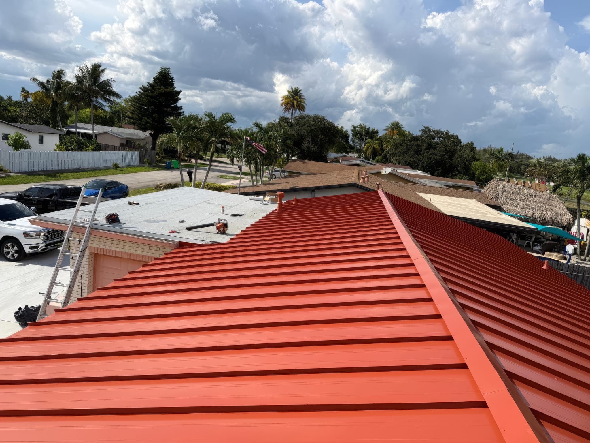 Drone view of the completed red metal roof and the neighborhood beyond