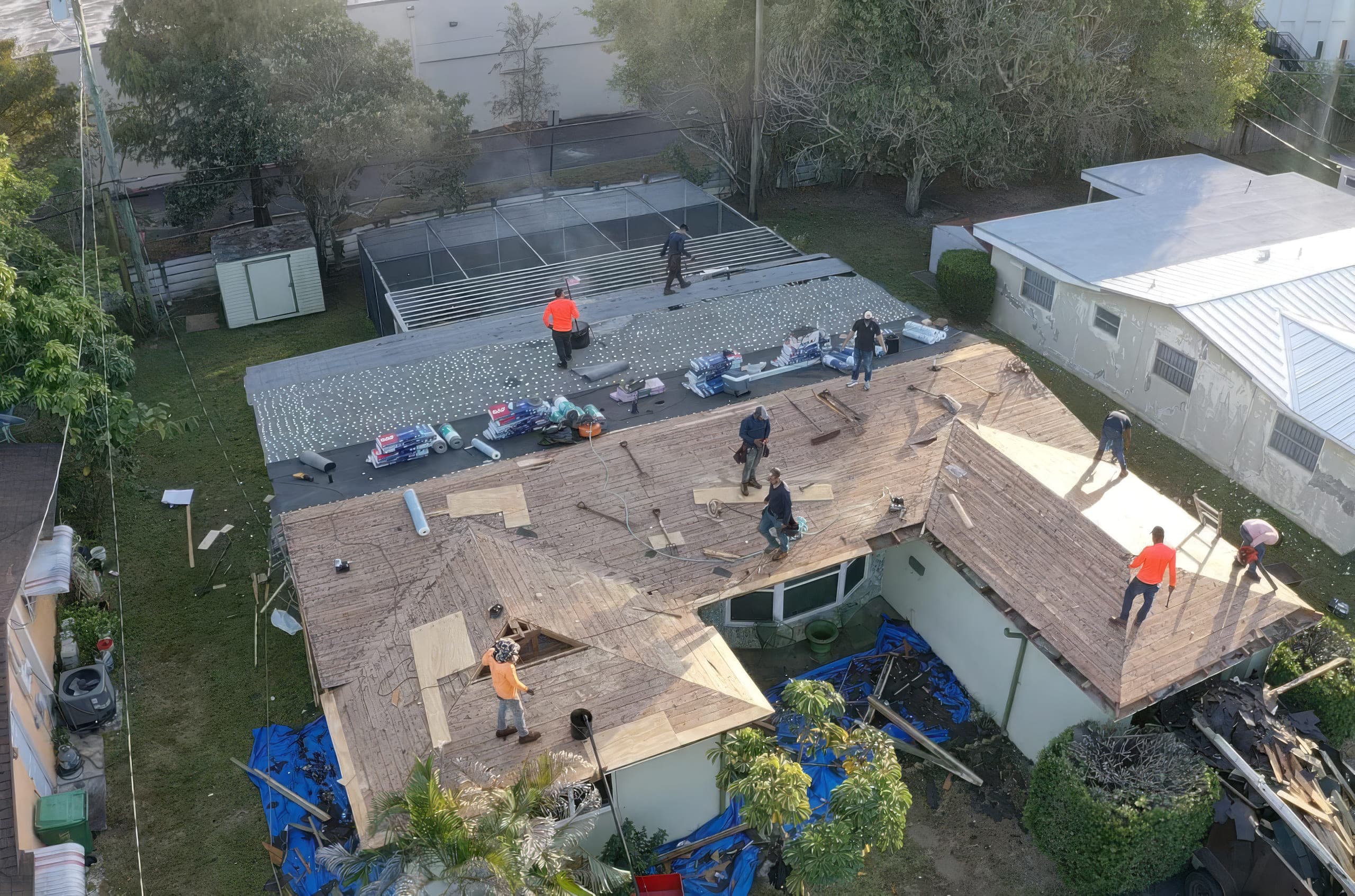 Crew on the roof tearing off old shingles down to the decking