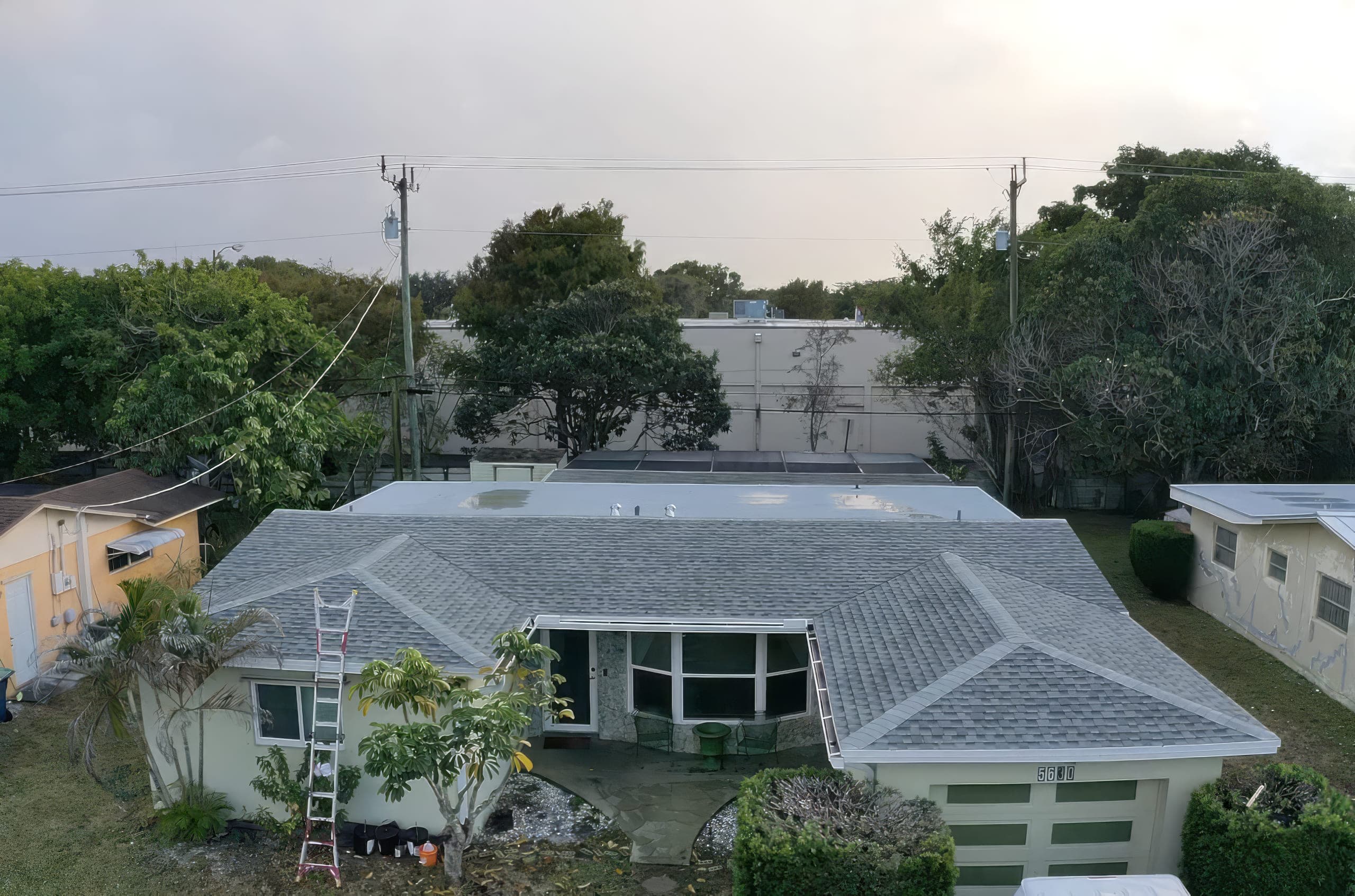 Finished grey architectural shingle roof seen from the street at dusk