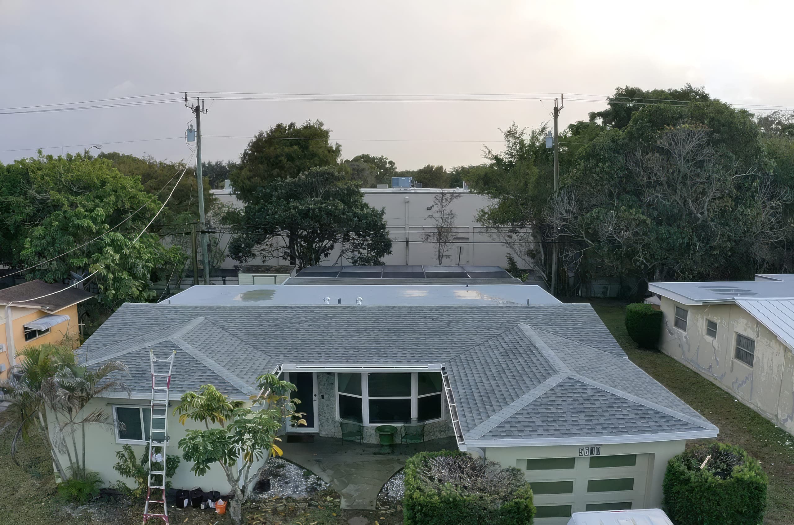 New shingle roof on the single-story home, ladder still at the eave on the last day