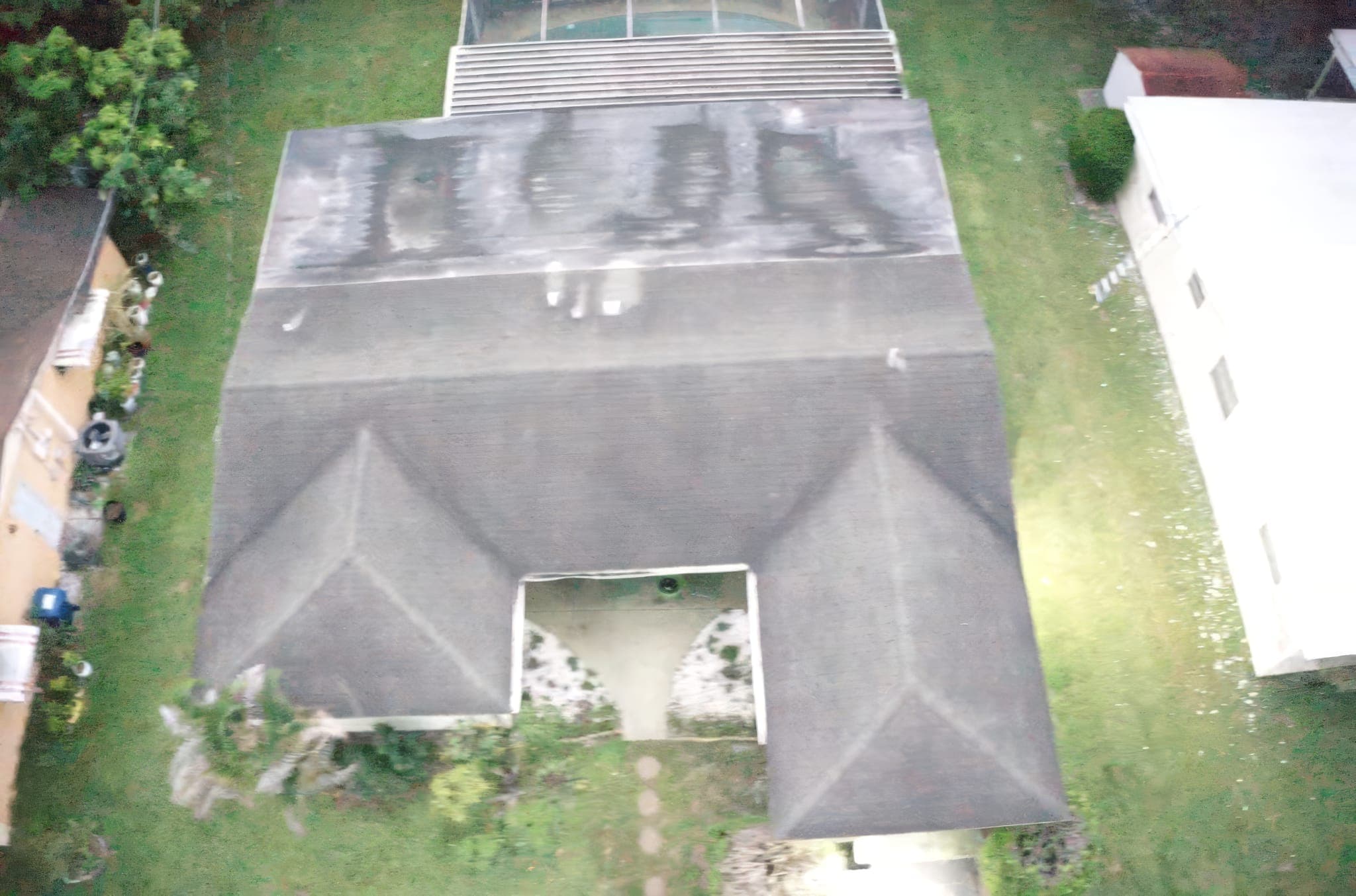 Drone photo of a hip shingle roof with algae streaks