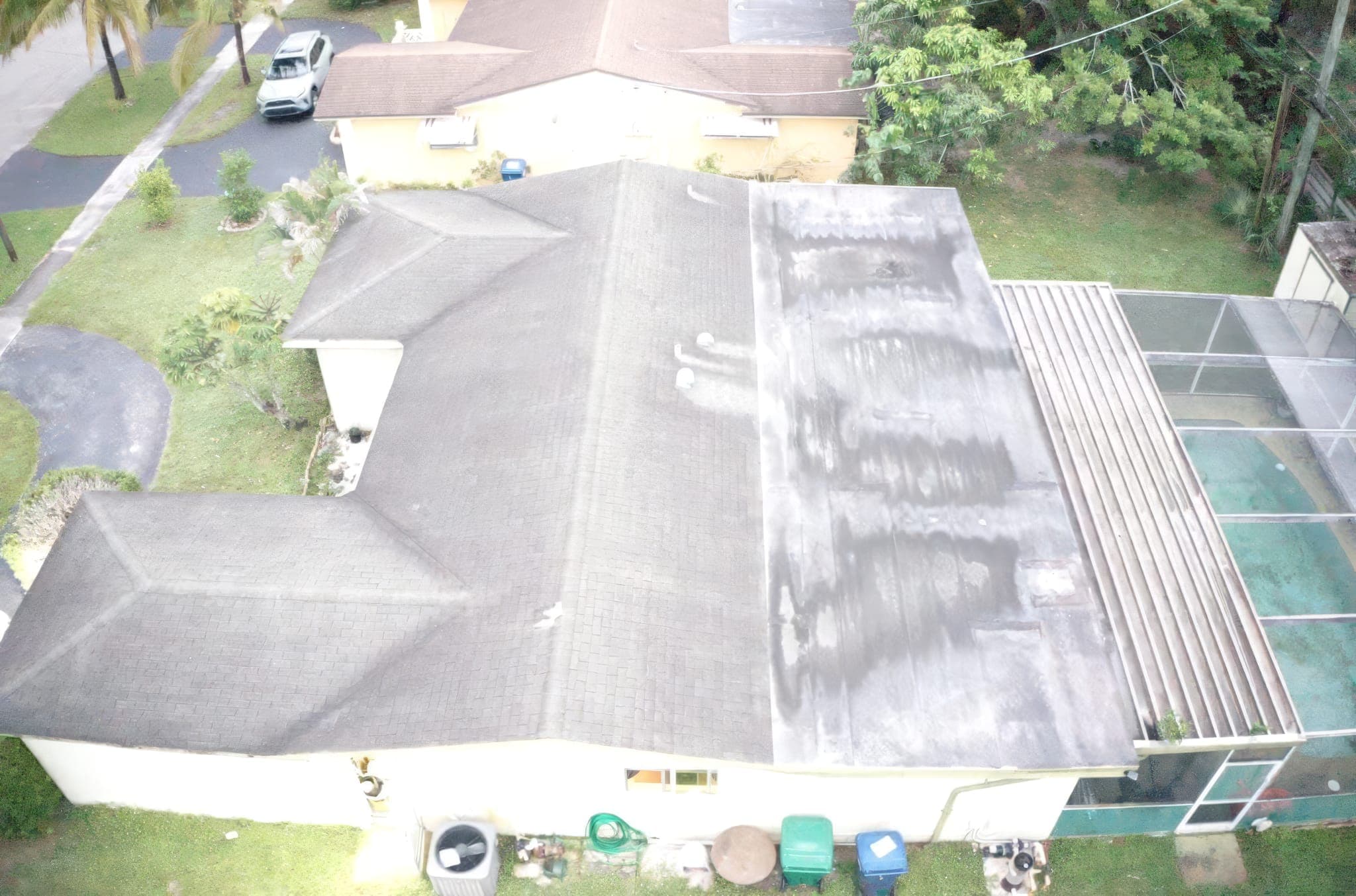 Drone view of a shingle roof with a flat patio section