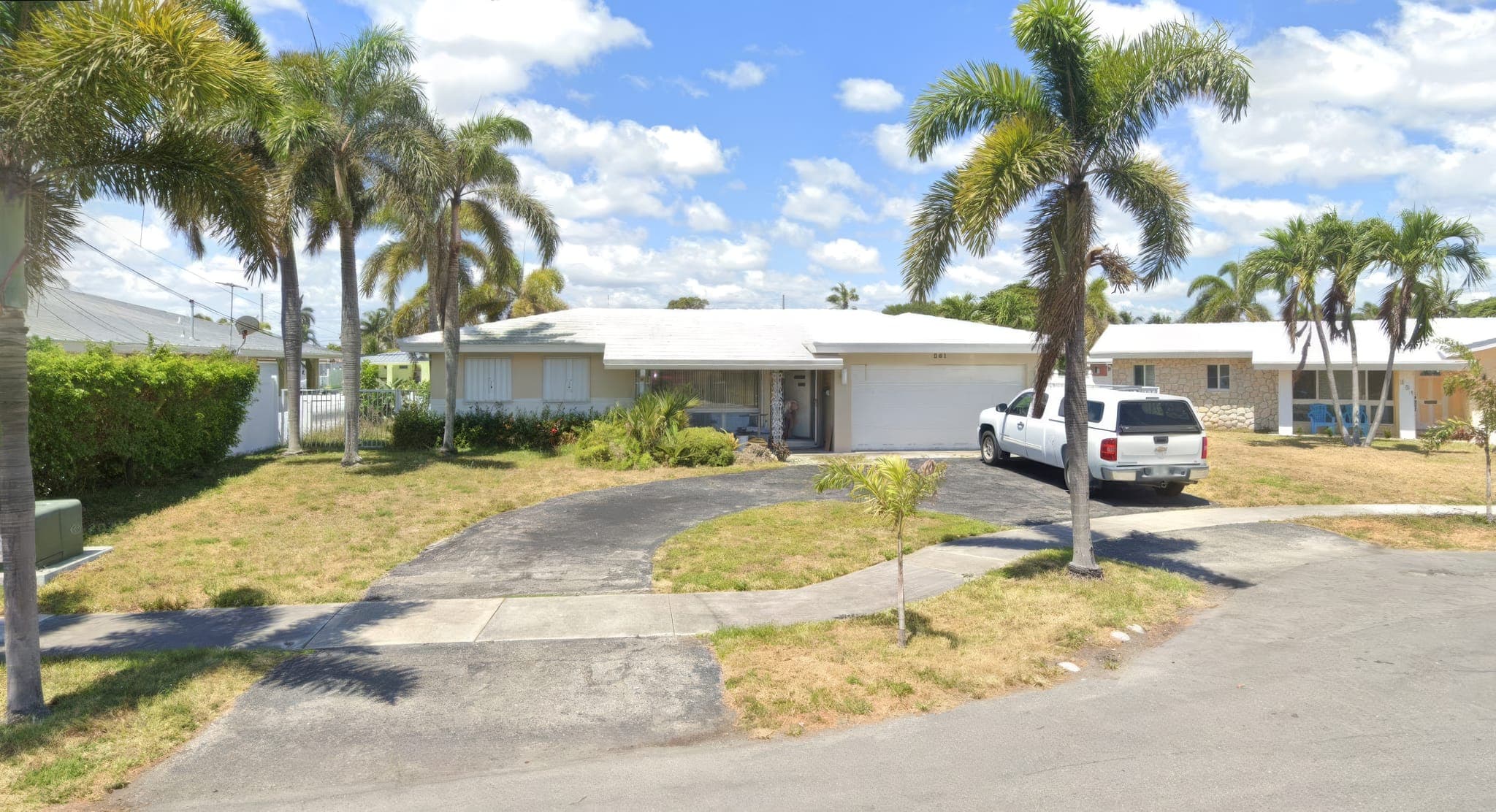 Single-story canal-front home with its old roof before the tile re-roof