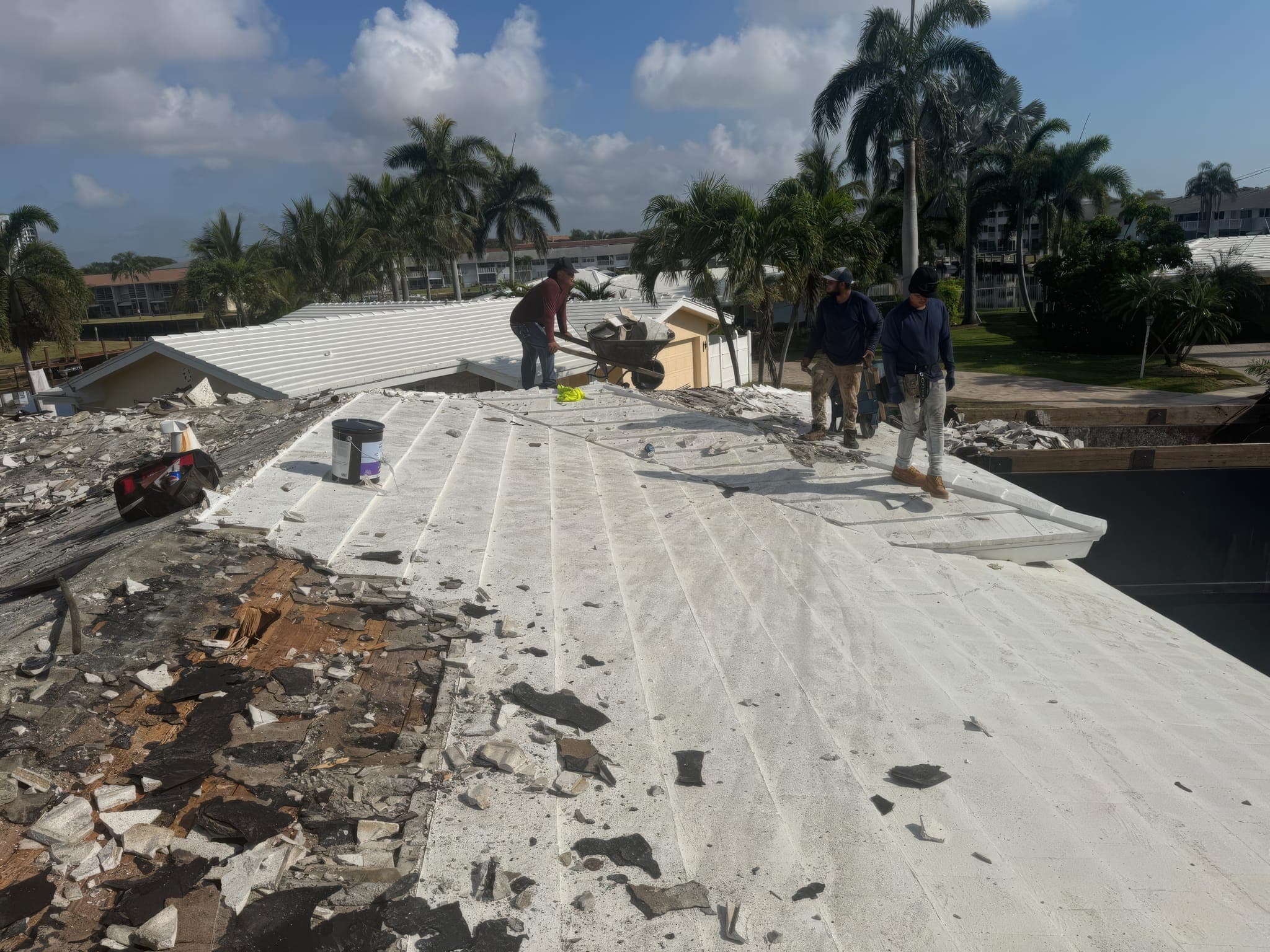 Old roof stripped and the deck being dried in, crew working toward the ridge