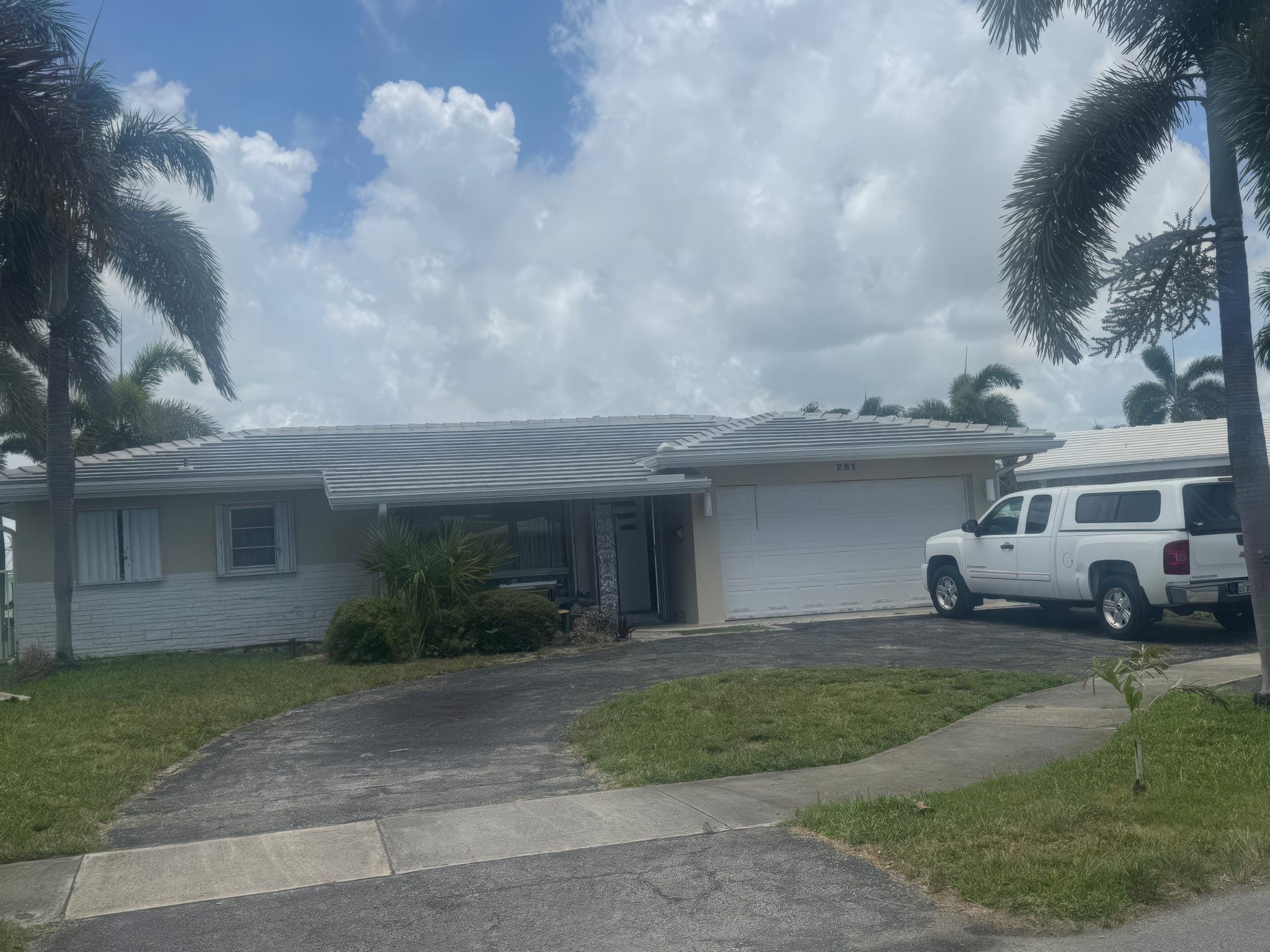 Finished white flat tile roof on the single-story home, seen from the street